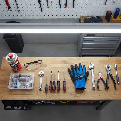 Essential tools for safely cleaning a pole saw carburetor laid out on a workbench